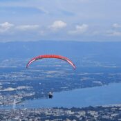 A paraglider flies above Lac Leman and Geneva with the Jet DEau seen – Étrembières